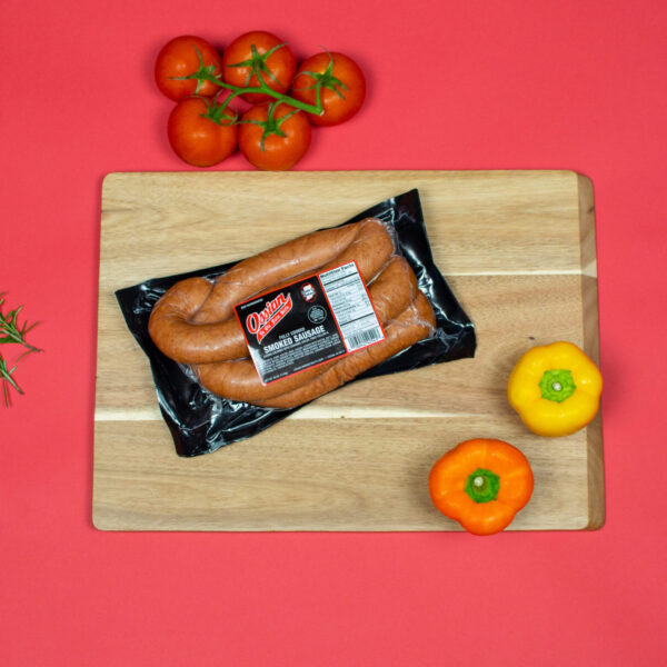 Pork Smoked Sausage on cutting board next to vegetables